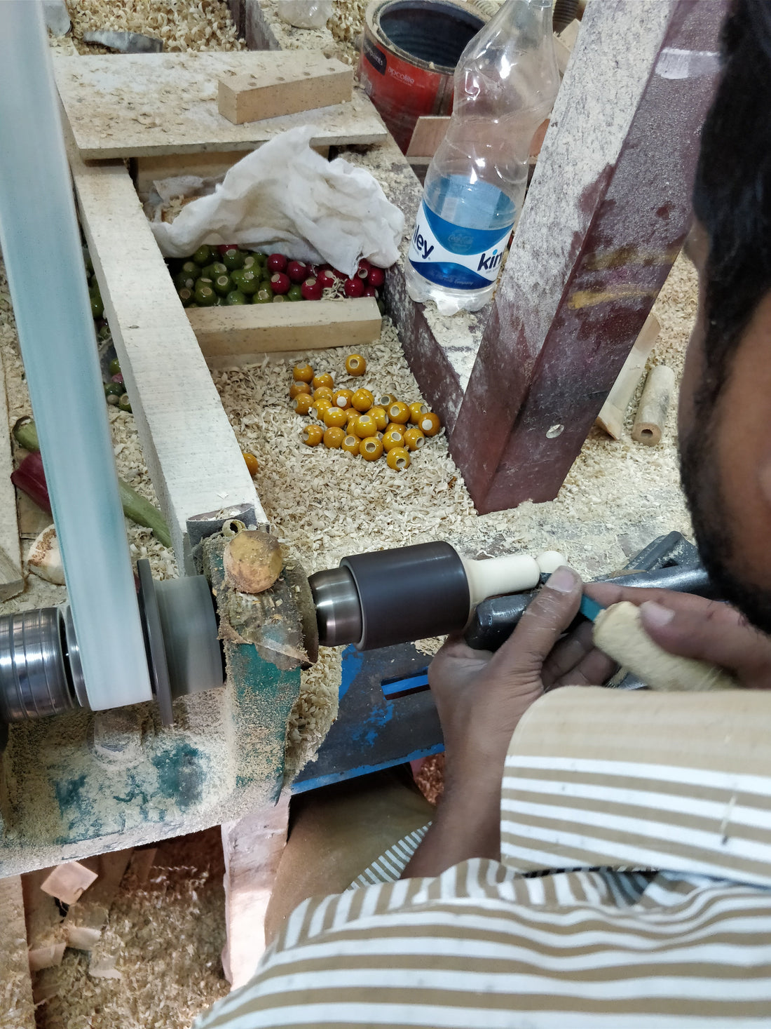 A Channapatna artisan coloring a turned toy with a stick of lac at the lathe. Photo: Kartik Mistry, Wikimedia Commons, CC BY-SA 4.0